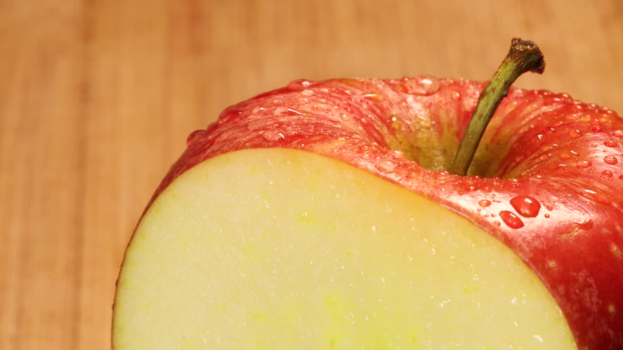 Meget skarp kniv skærer en skive af et rødt æble, makrooptagelse