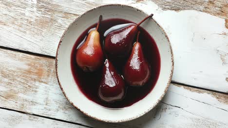 delicious pears poached in red wine on rustic table