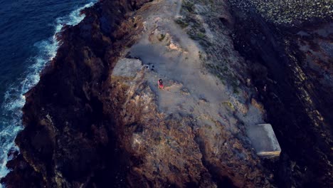 Überholen-Sie-Den-Schuss-Eines-Felsigen-Hügels,-Der-Von-Blauem-Meerwasser-In-Los-Cristianos,-Teneriffa,-Umgeben-Ist