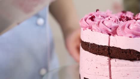 cortando un pastel de capa de frambuesa rosa