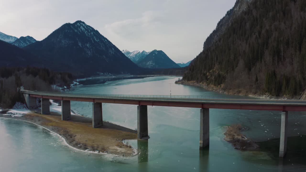 Anamorphic 4K Aerial Drone footage of the scenic bridge across the Bavarian water reserve lake Sylvenstein in southern Germany in the mountains in cinema format.
