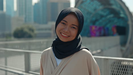 close-up portrait of a young muslim woman in hijab smiling in an urban setting