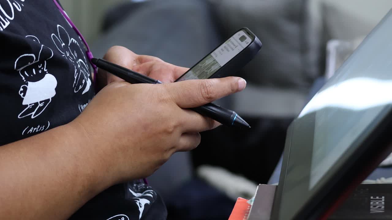 persona que utiliza un teléfono inteligente, posiblemente enviando mensajes de texto o navegando.