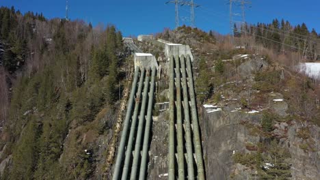 old discontinued water pipelines from tunhovd dam to hydroelectric powerplant nore i in rodberg norway - aerial overview of massive pipelines coming down hillside