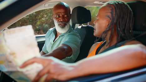 senior couple in car with map arguing about directions on day trip out