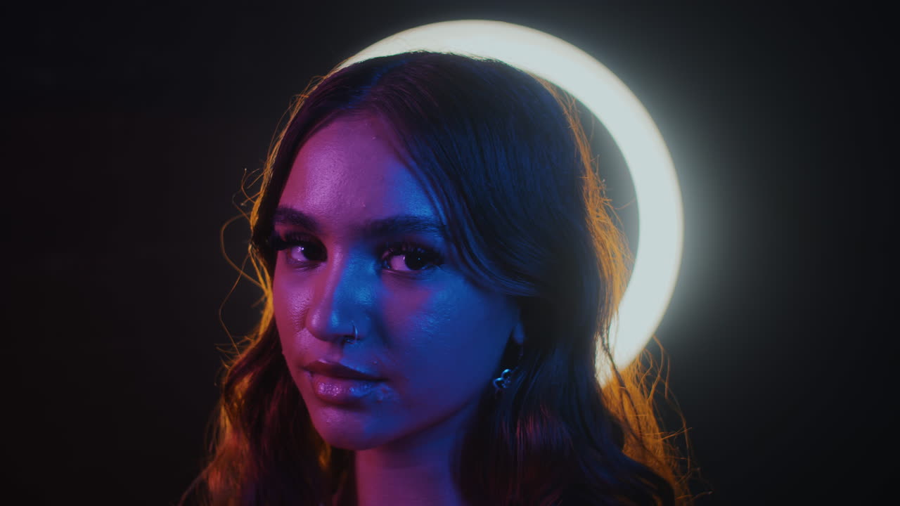 Smiling Asian Woman Posing for Camera in Neon Studio