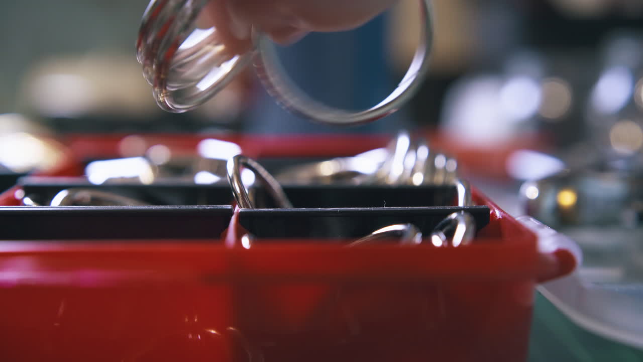 전문 디자이너의 손은 둥근 금속 액세서리를 취합니다.