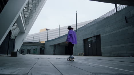 Active-hipster-riding-on-longboard-outdoors.-Skateboarder-enjoying-speed.