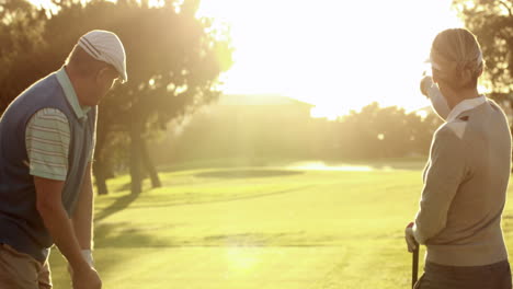 Pareja-Feliz-Jugando-En-El-Campo-De-Golf