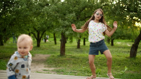 Cute-children-making-rhythmical-movements-outdoors.-Brother-and-sister-dancing