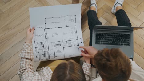 estudiantes de ingeniería y arquitectura trabajando en un proyecto universitario utilizando los planos y planos de una casa