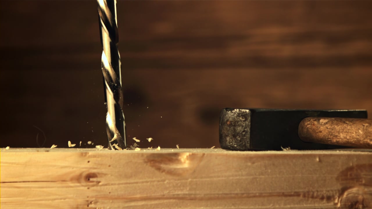 Slow Motion Close-Up of a Drill Bit Drilling into Wood