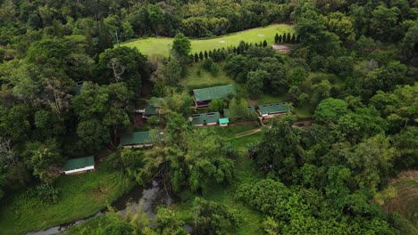 toma aérea en movimiento hacia adelante sobre un helipuerto rodeado de un exuberante bosque verde en el parque nacional tham pla-pha suea