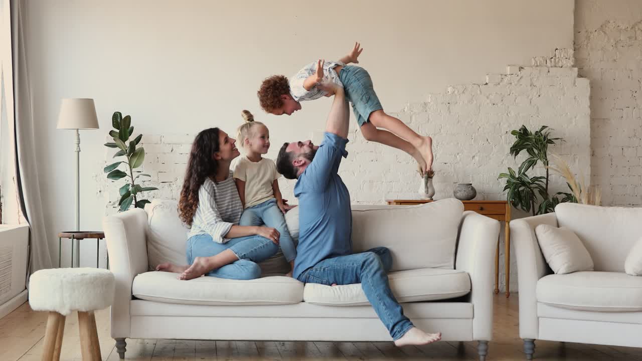 una pareja con dos hijos juega en una acogedora sala de estar.