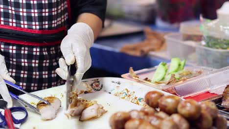 vendor slicing pork at night market stall