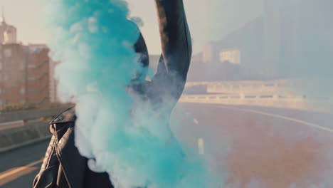 mujer agitando bomba de humo azul en la calle de la ciudad chica celebrando la libertad creativa cámara lenta