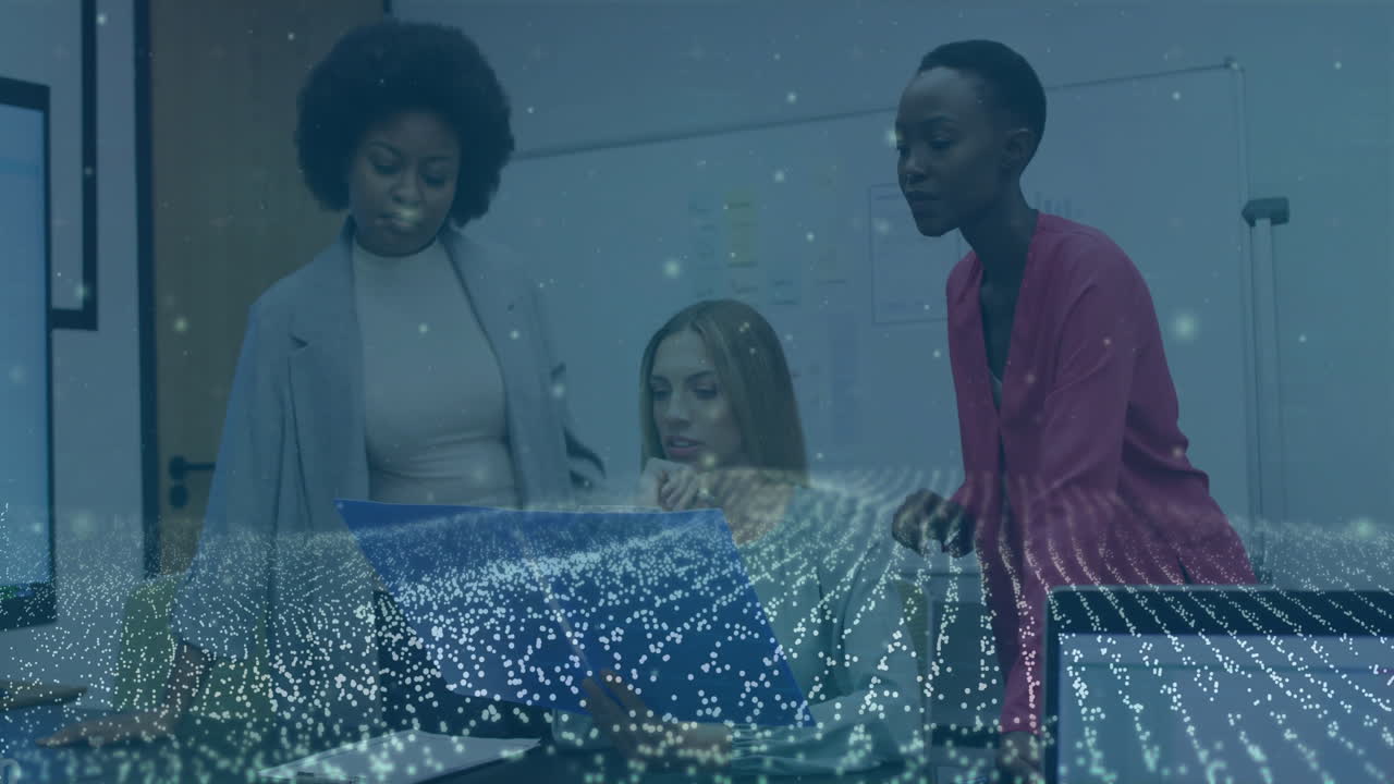 Collaborating on animation and digital data, three women in office environment