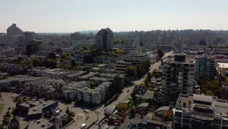 3-4 vuelo panorámico aéreo sobre la isla de granville superior residencial comercial de lujo moderna comunidad de poca altura junto a las tiendas minoristas y los exuberantes parques verdes en el centro de vancouver, canadá, vista suroeste
