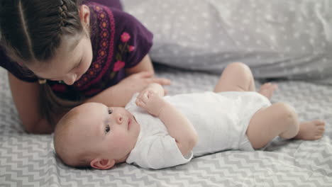 niña besando bebé recién nacido acostado de espaldas. concepto de amor hermana