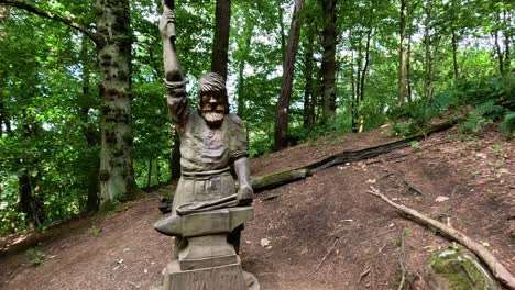 estatua de piedra en medio de un paisaje de bosque verde y exuberante