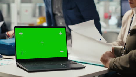 industrial plant manager typing on green screen laptop