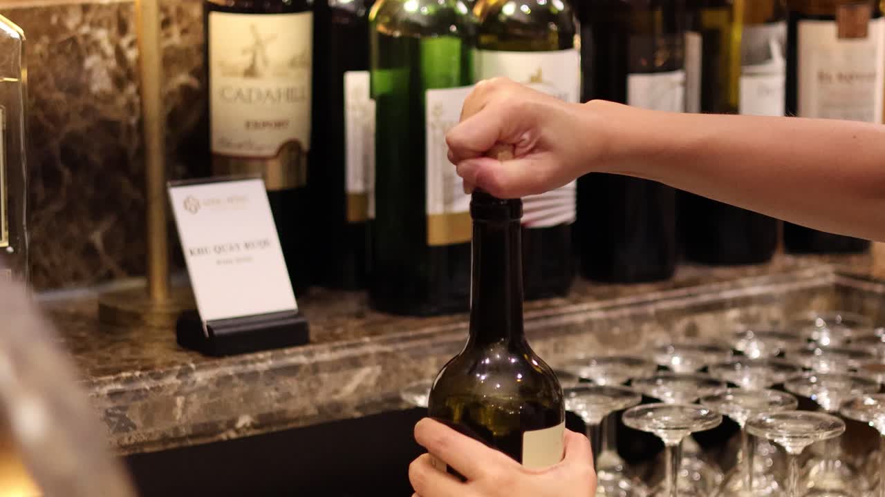 Mani che stappano una bottiglia di vino
