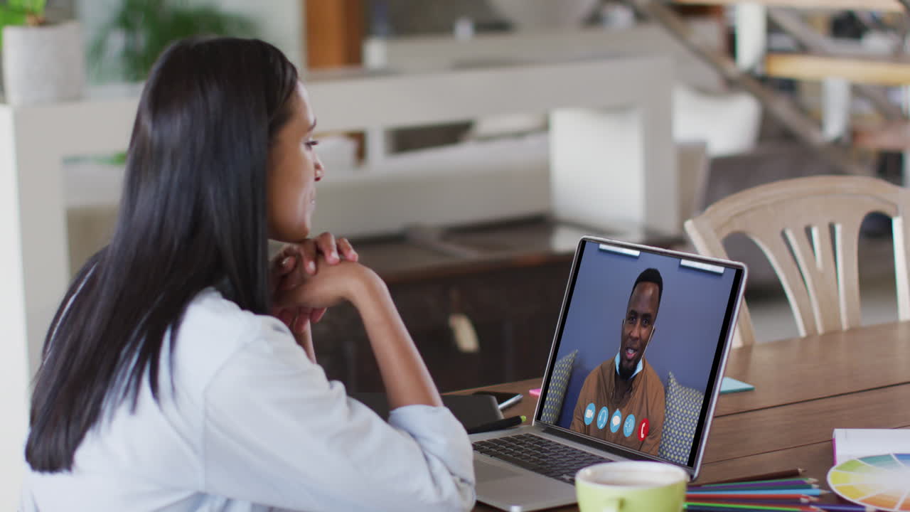 Caucasian woman using laptop on video call with male colleague working from home