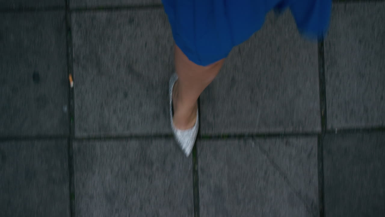 mujer caminando por la acera vistiendo elegante vestido de fiesta de noche elegantes zapatos brillantes paseando por la vida nocturna de la ciudad urbana