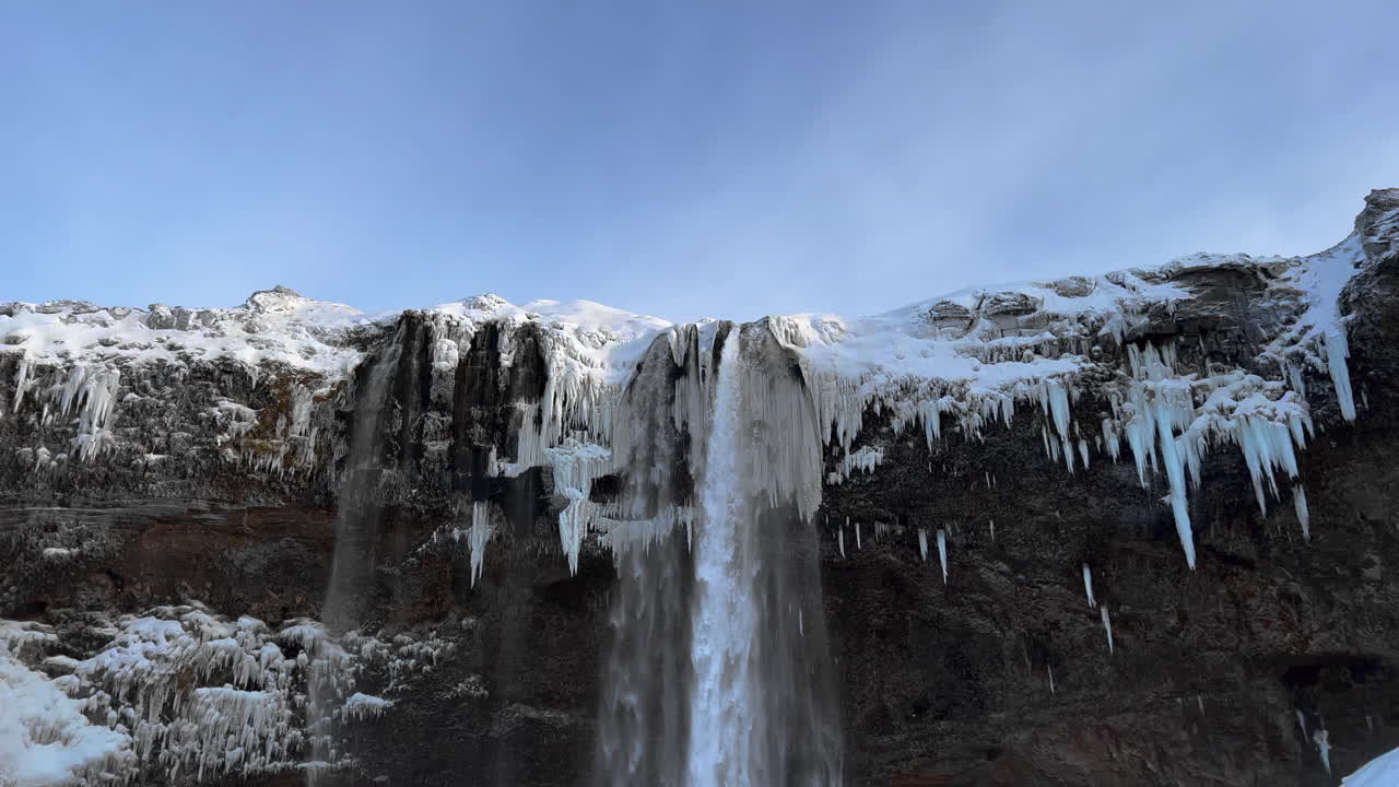 tiro inclinado hacia abajo de la espectacular cascada helada de seljalandsfoss en invierno durante la luz del sol