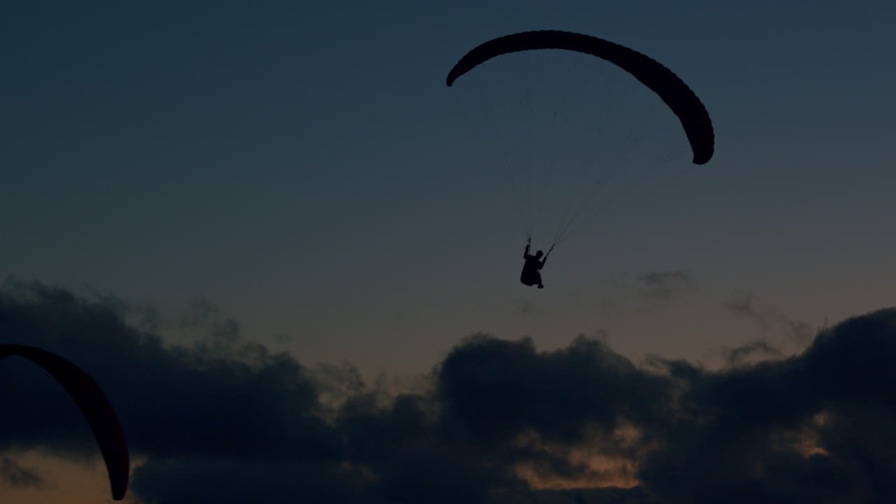 포르투갈의 대서양 해안 근처를 날아다니는 패러글라이더와 함께 천상의 아름다운 색을 즐기면서 느린 동작으로 촬영되었습니다.