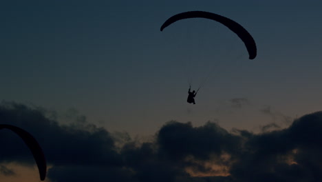 slow motion shot with paragliders flying close to the atlantic coast of portugal, while enjoying the beautiful colors of the sky