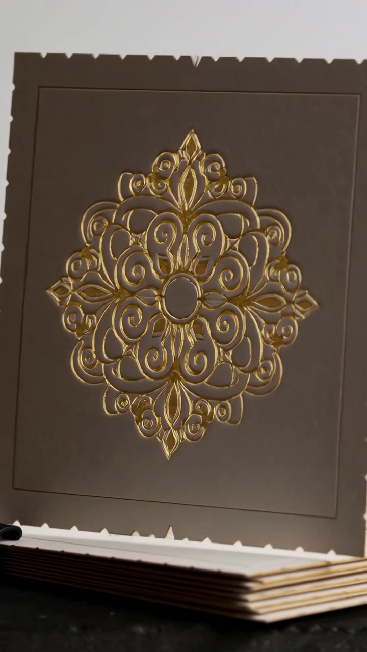 Vertical video: Tilting camera revealing scalloped card on stack on table, showing gold mandala