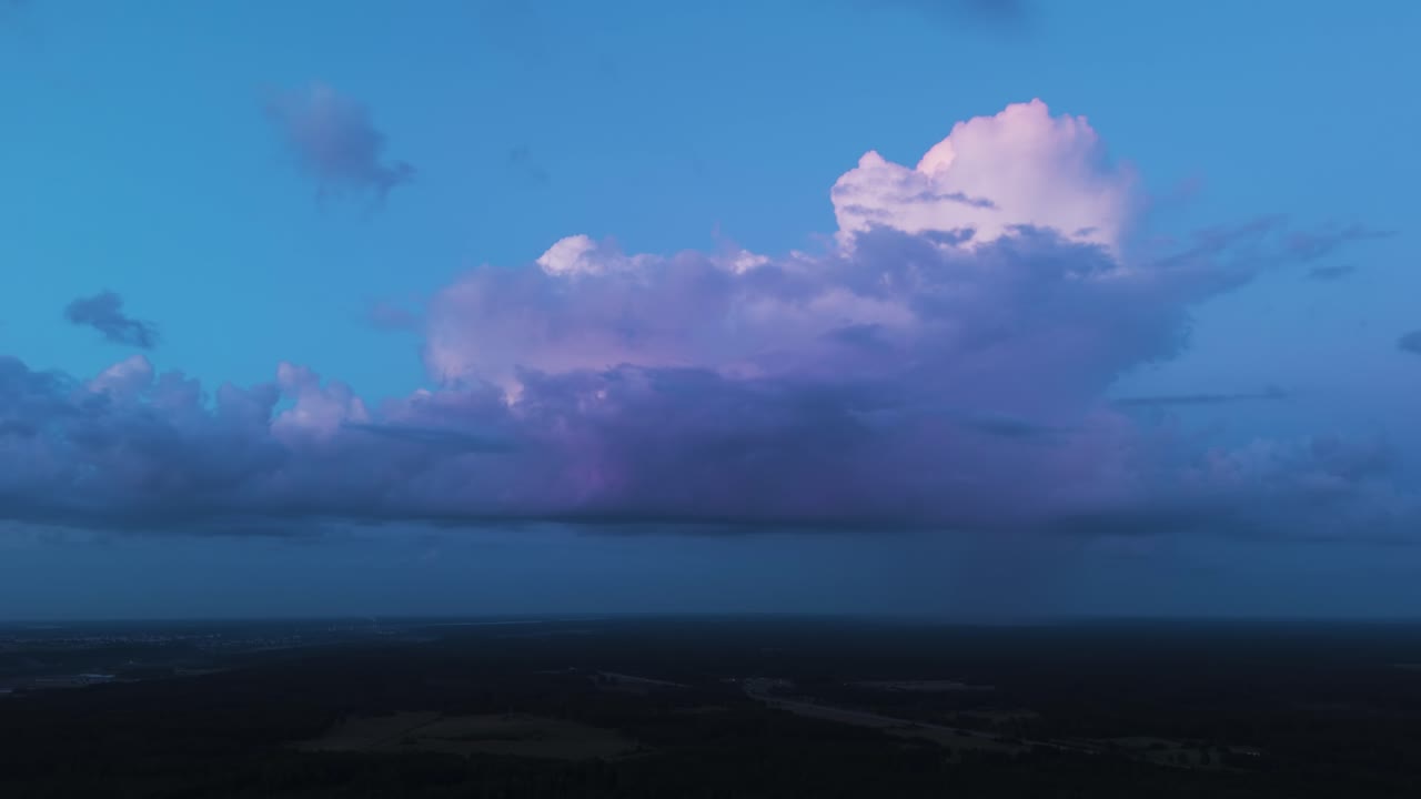 Massive rainfall clouds flowing above Lithuania landscape, aerial drone view