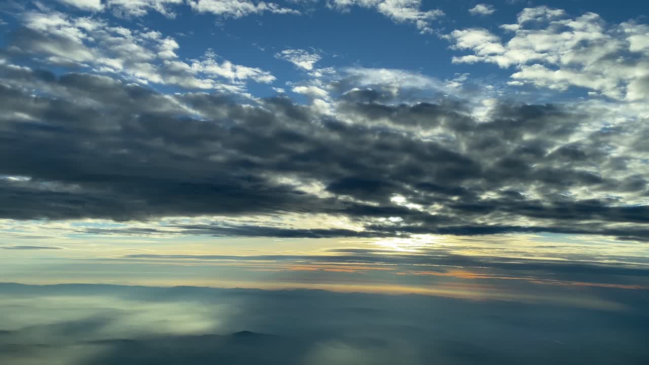 vista aérea volando debajo de las nubes antes de la puesta del sol