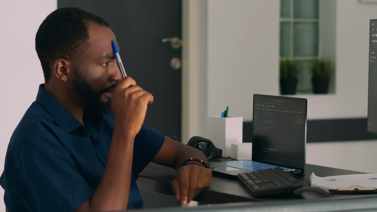 Pensive african american programer working on code development