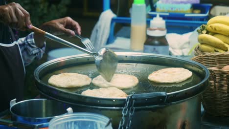 4k cinematic cooking footage of a thai chef preparing a traditionnal thai dessert called roti in a street market in thailand