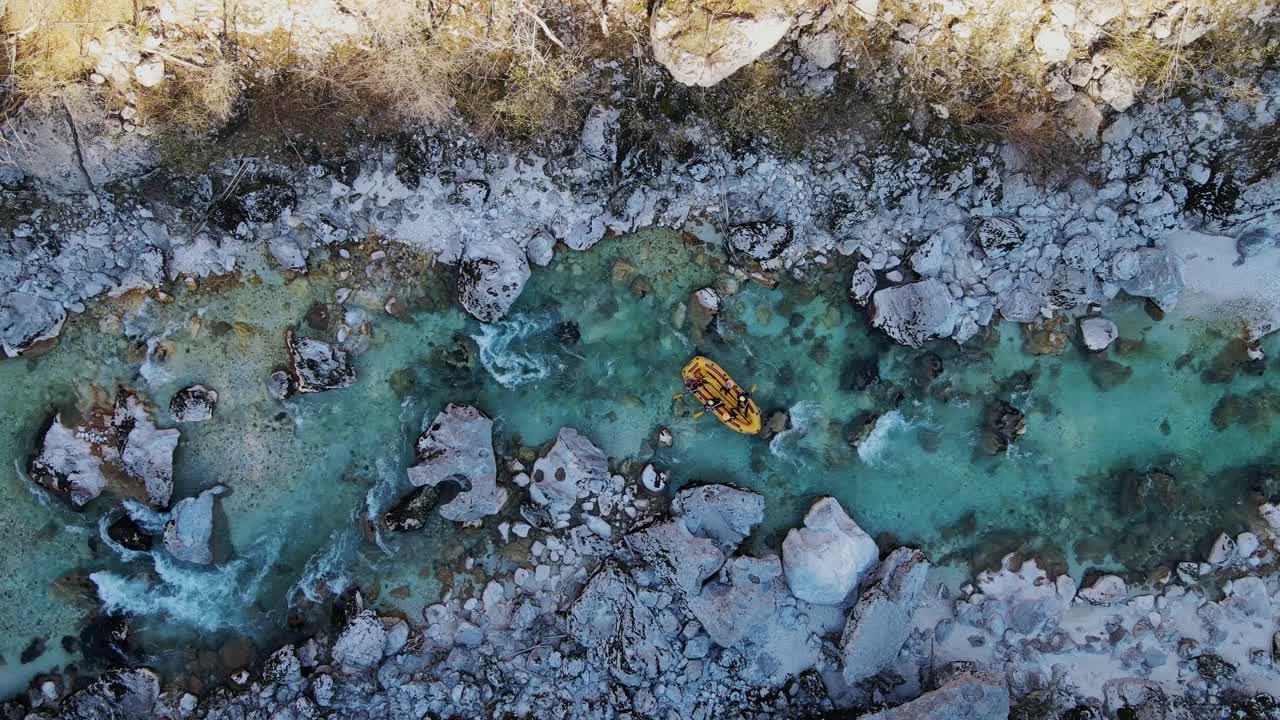Drone follows a raft navigating the crystal-clear Soča River through rocky rapids