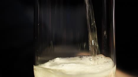 Pouring-sparkly-beverage-into-a-glass,-raising-the-carbonization-foam-from-the-trapped-air---Close-up-shot