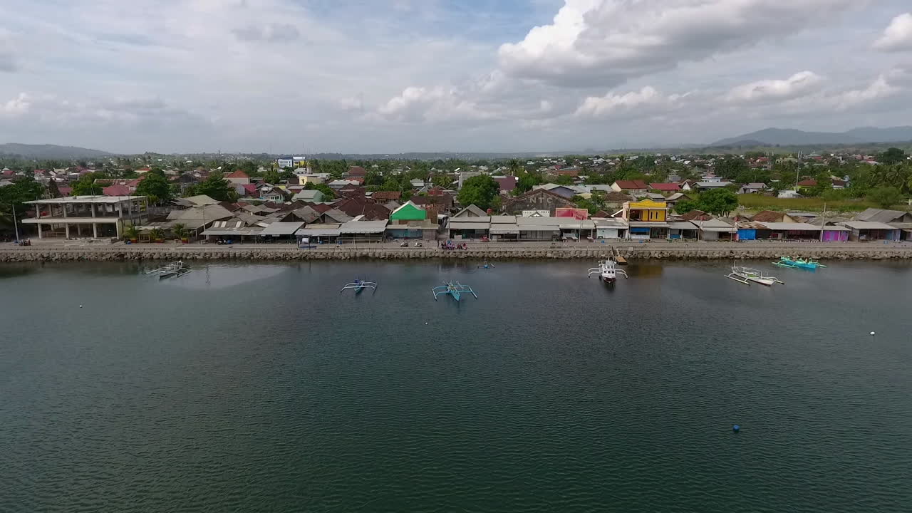 drone fly over Jempol Beach, Sumbawa island, Indonesia. traditional fisherman boat and little rural village unique travel destination