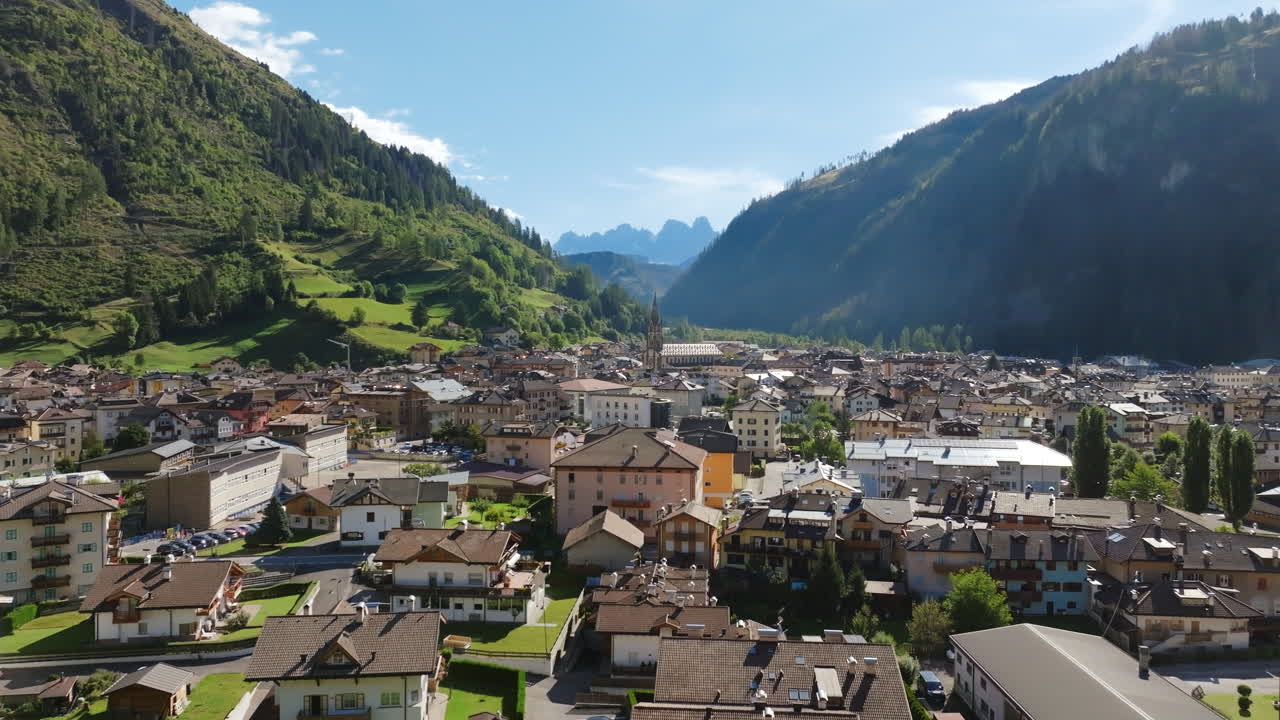 Slow aerial footage of a quaint Italian town nestled in a valley in the Dolomites.