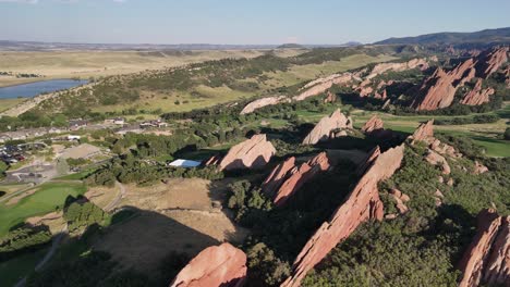 sunny aerial descends to angled rock fins in mountain foothills of co