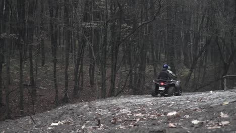 man with girlfriend ride a quad on the misty forest road