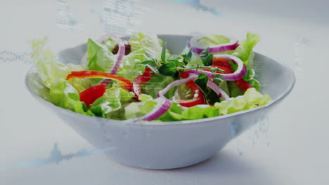 in white bowl, fresh salad with lettuce, red onions, and peppers