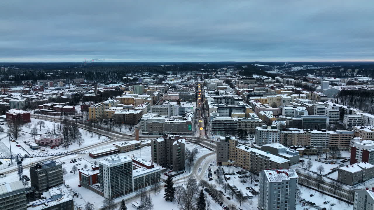 Drone reversing over streets in downtown Lahti, gloomy, winter evening in Finland