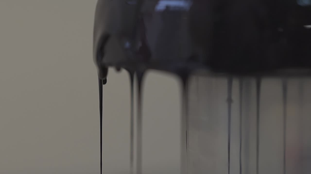 어두운 두꺼운 글레이즈 방울이 조리 표면에 천천히 흘러내립니다.