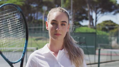 Video-of-caucasian-female-tennis-player-holding-racket-and-looking-at-camera