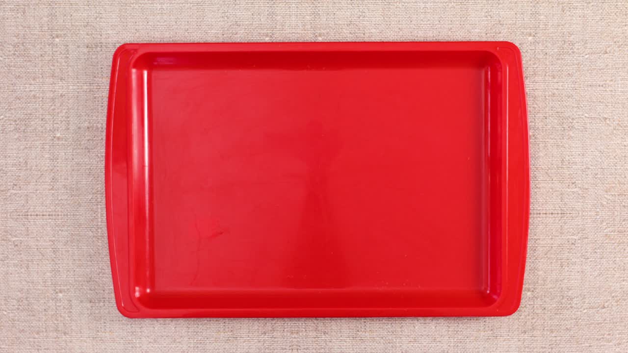 Organic vegetables and fruits appear in tray on kitchen table. Stop motion