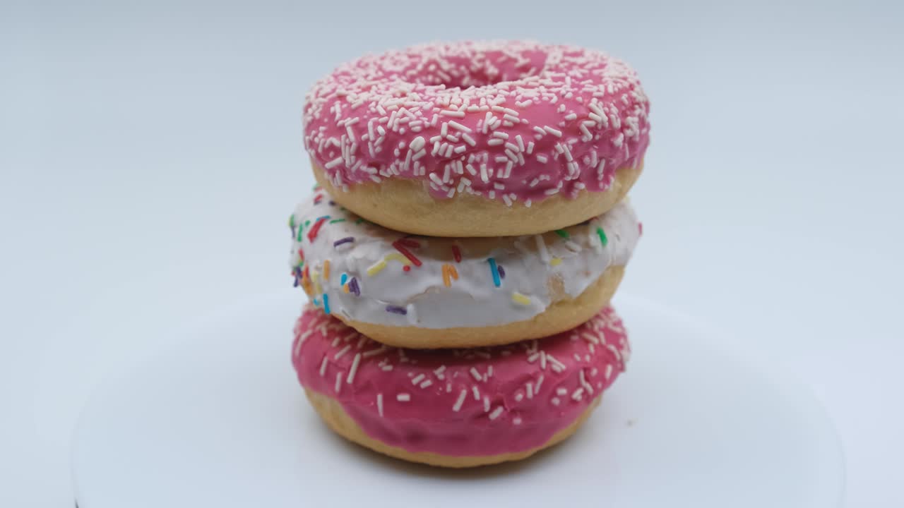 rotación de primer plano de tres rosquillas dulces apiladas una encima de la otra en forma de torre
