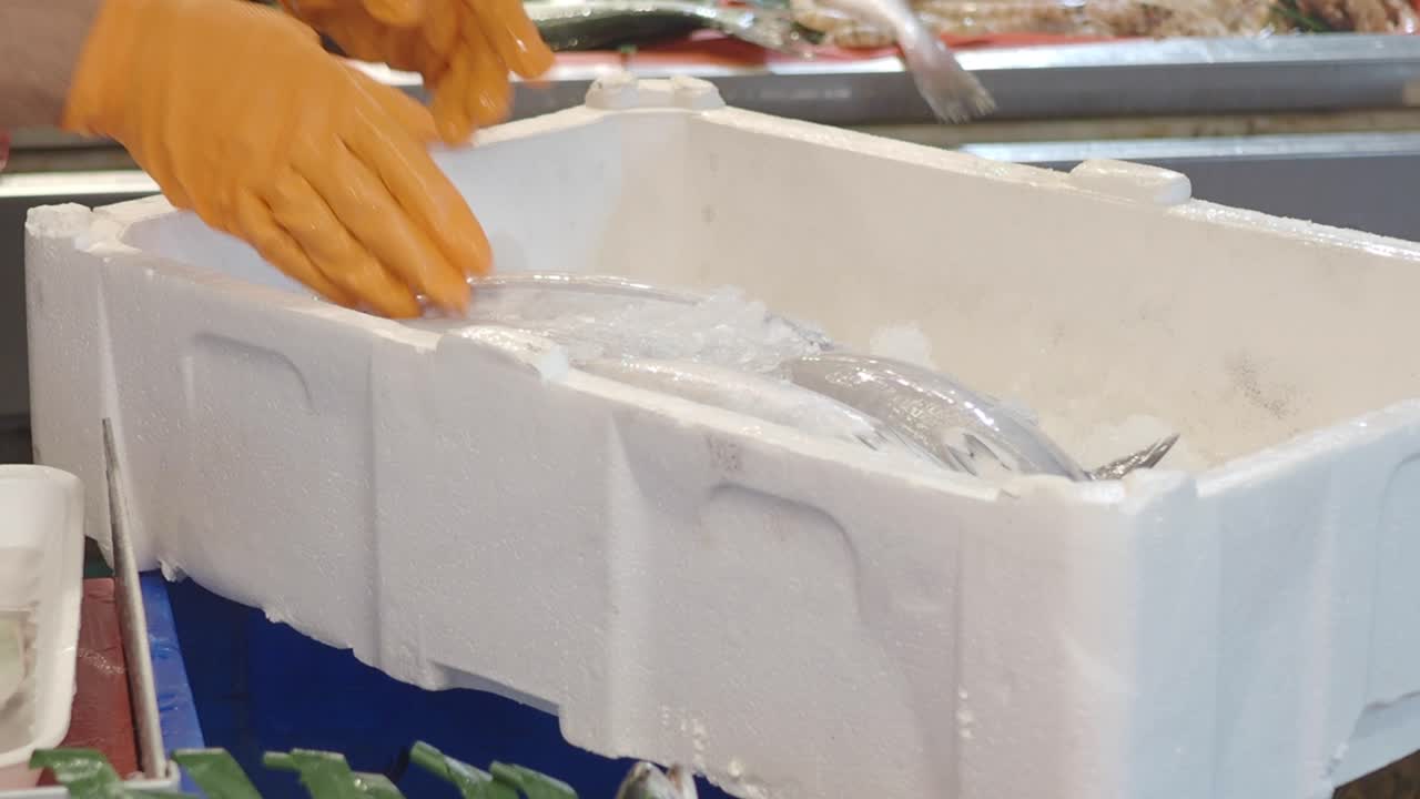 Fishmonger Handling Fresh Fish at a Market