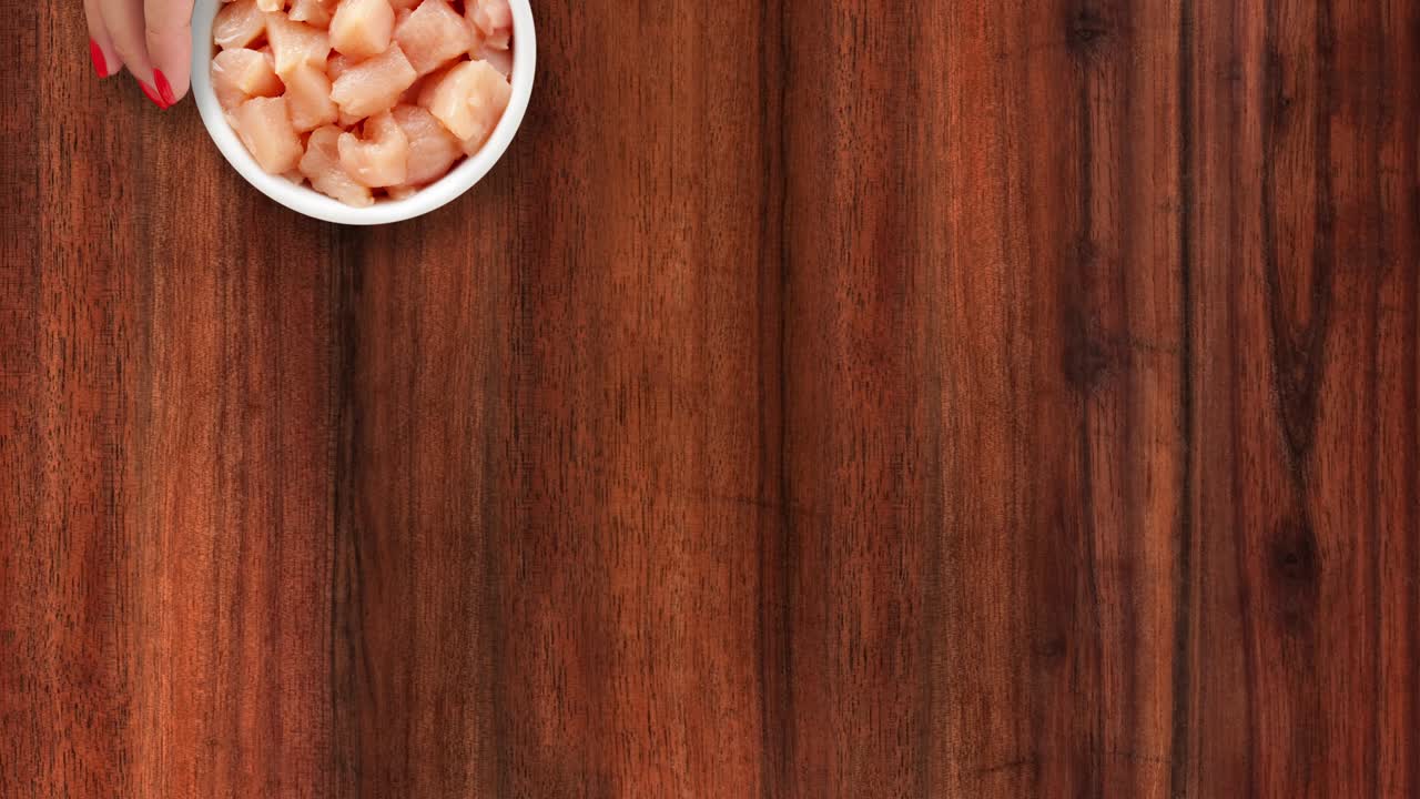 ofreciendo carne de pollo cruda en cubitos